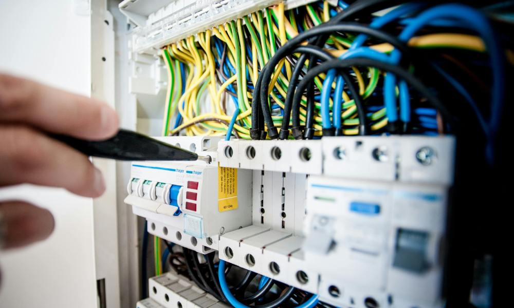 Electrician Fixing an Opened Switchboard Electrician Fixing an Opened Switchboard