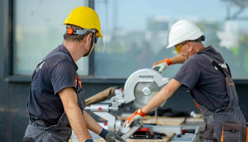 Workers Cutting Metal Beam with Saw Workers Cutting Metal Beam with Saw