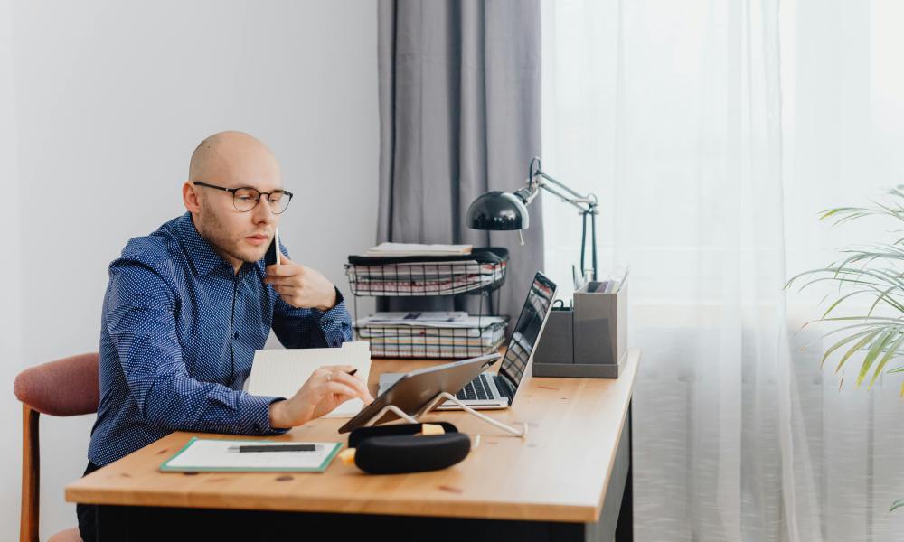man-sat-at-desk-with-telephone