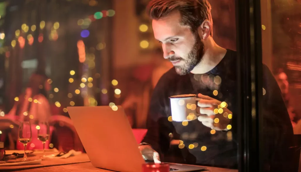 man working at laptop in coffee shop