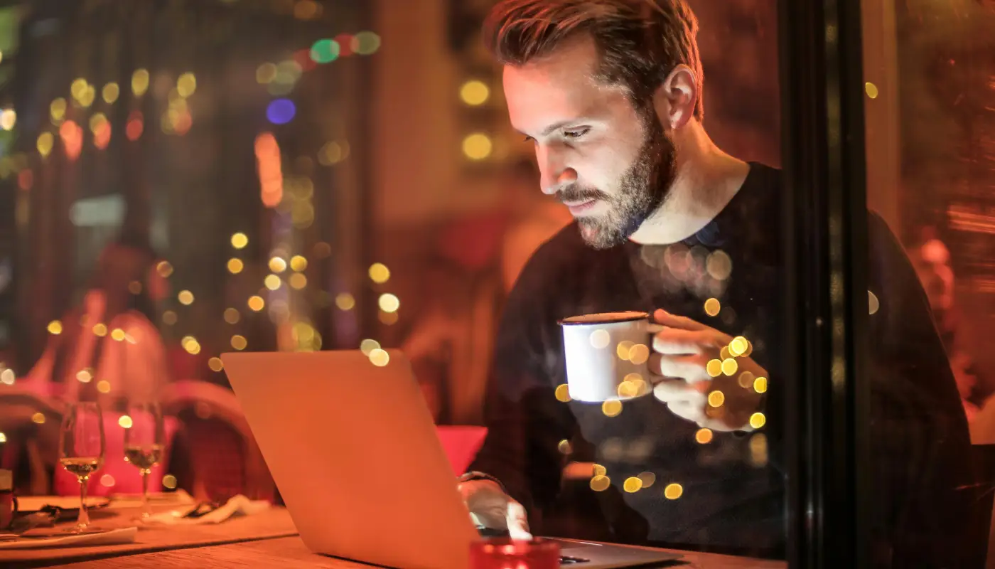 man working at laptop in coffee shop