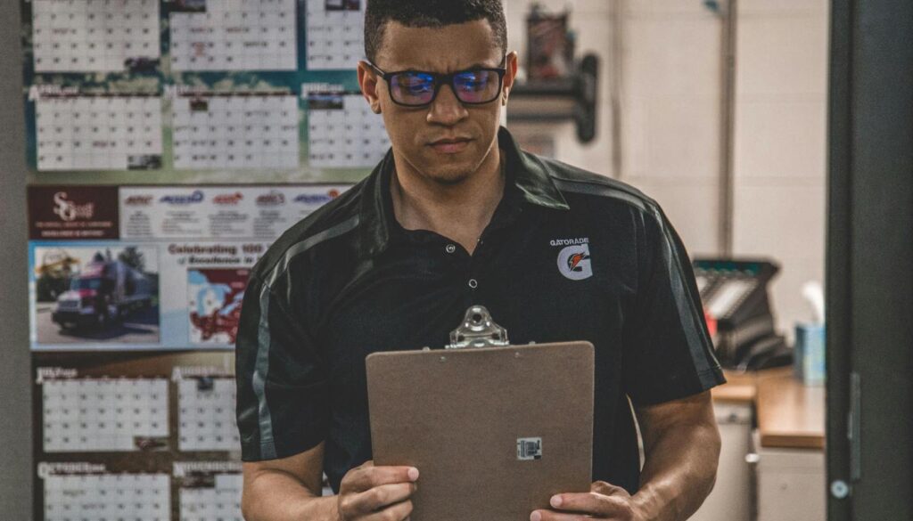 man holding clipboard with job sheet